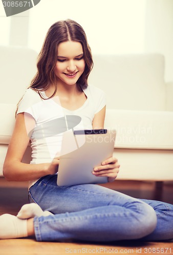 Image of smiling teenage girl with tablet pc at home