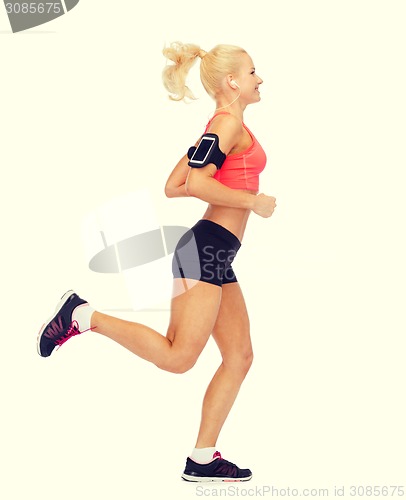 Image of sporty woman running with smartphone and earphones