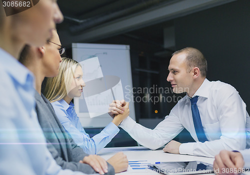 Image of businesswoman and businessman arm wrestling