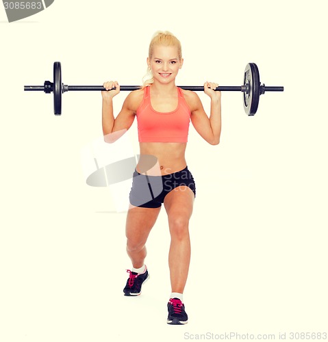 Image of smiling sporty woman exercising with barbell