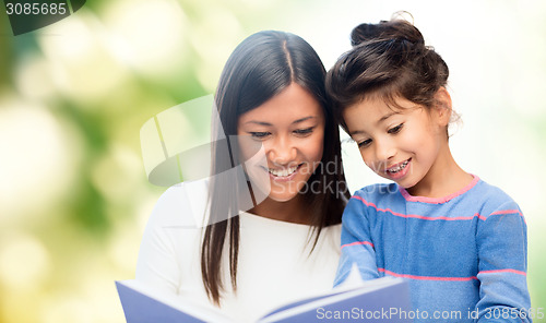 Image of happy mother and daughter reading book