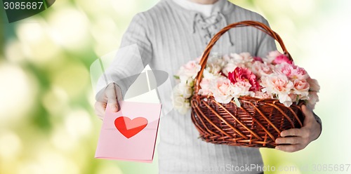 Image of man holding basket full of flowers and postcard