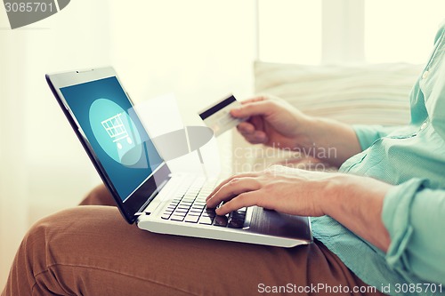 Image of close up of man with laptop and credit card