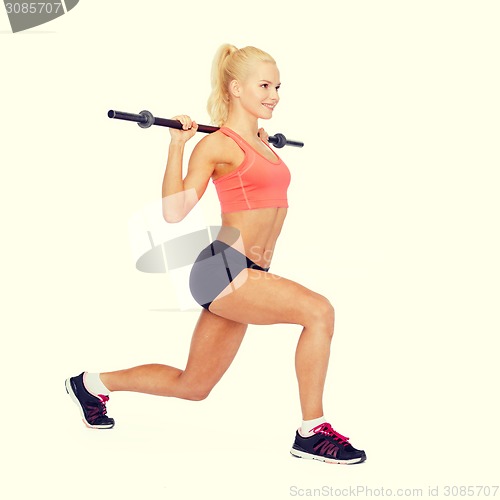 Image of smiling sporty woman exercising with barbell