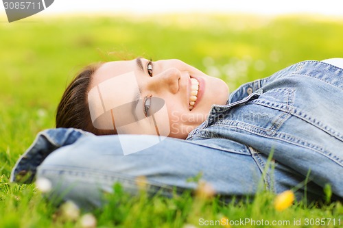 Image of smiling young girl lying on grass