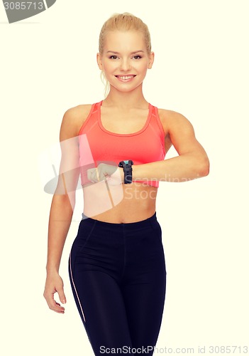 Image of smiling woman with heart rate monitor on hand