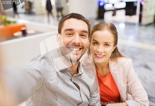 Image of happy couple taking selfie in mall or office