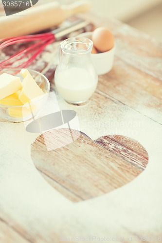 Image of close up of heart of flour on wooden table at home