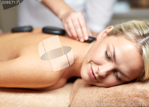 Image of close up of woman having hot stone massage in spa