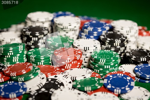 Image of close up of casino chips on green table surface