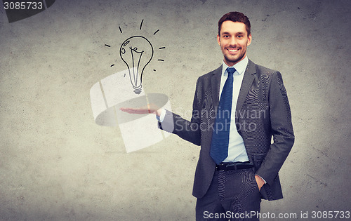 Image of man showing light bulb on the palm of his hand