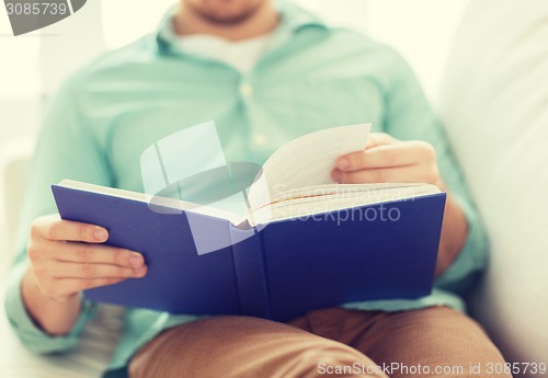 Image of close up of man reading book at home