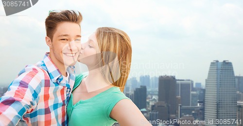 Image of happy couple taking selfie over city background