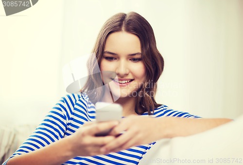 Image of smiling teenage girl with smartphone at home