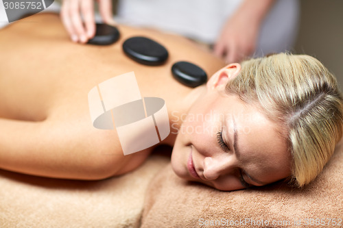 Image of close up of woman having hot stone massage in spa