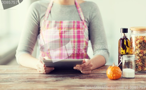 Image of closeup of woman reading recipe from tablet pc