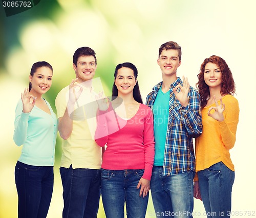 Image of group of smiling teenagers over green background