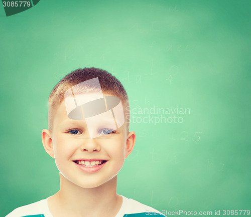 Image of smiling little boy over green board background