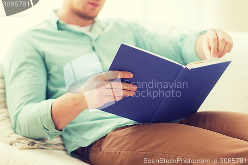 Image of close up of man reading book at home