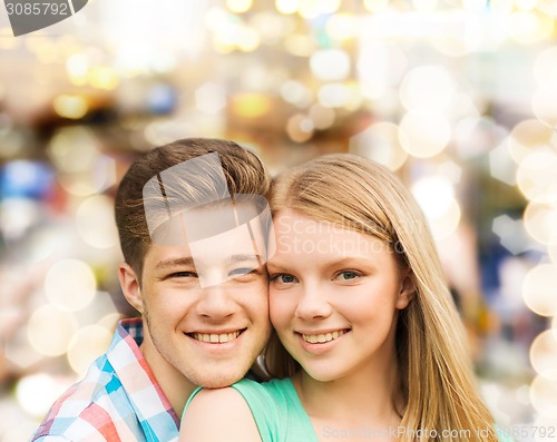 Image of smiling couple hugging over lights background