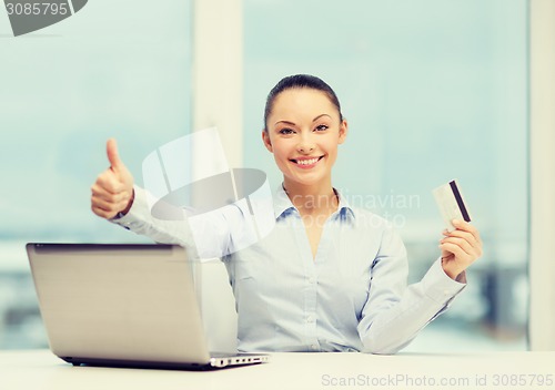Image of businesswoman with laptop in office