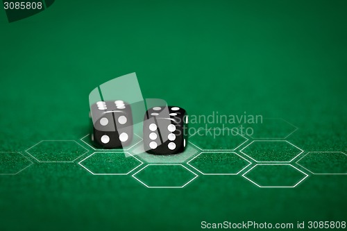 Image of close up of black dice on green casino table