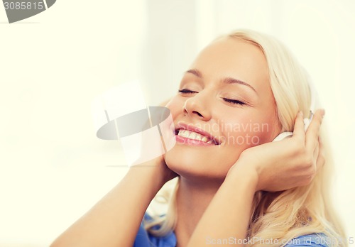 Image of smiling young girl in headphones at home