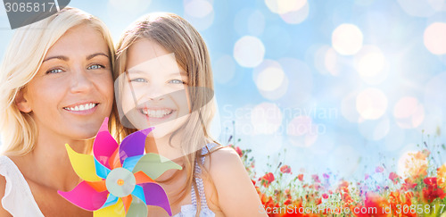 Image of happy mother and little girl with pinwheel toy