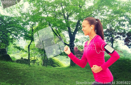 Image of smiling young woman running outdoors