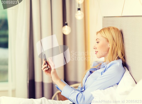 Image of happy businesswoman with smartphone in hotel room