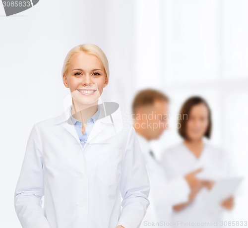 Image of smiling female doctor with group of medics