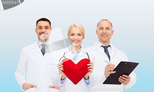 Image of group of smiling doctors with heart and clipboard