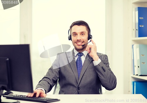 Image of helpline operator with headphones and computer