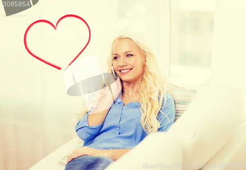 Image of smiling woman with smartphone at home