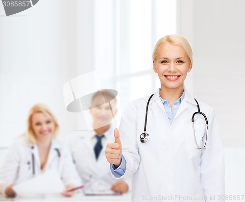 Image of smiling female doctor showing thumbs up