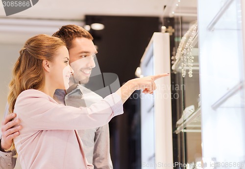 Image of couple looking to shopping window at jewelry store