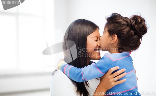 Image of happy little girl hugging and kissing her mother