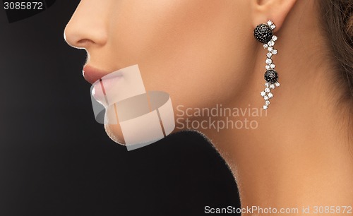 Image of woman wearing shiny diamond earrings