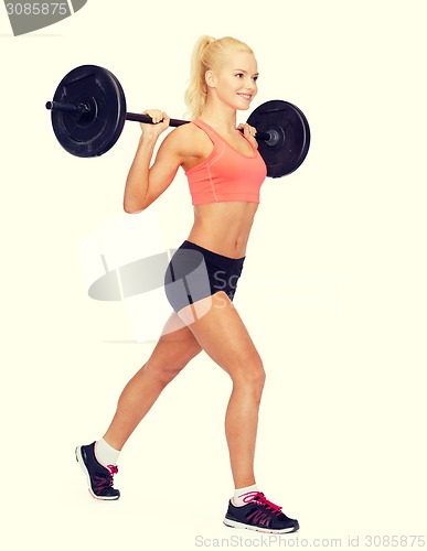 Image of smiling sporty woman exercising with barbell