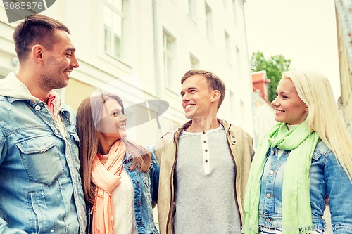 Image of group of smiling friends walking in the city