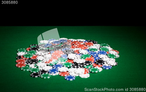 Image of close up of casino chips on green table surface