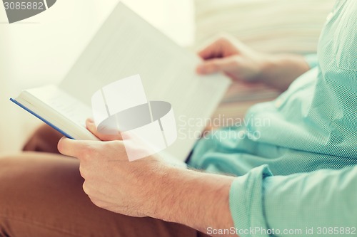 Image of close up of man reading book at home