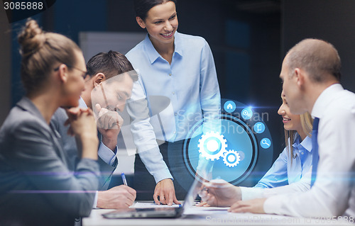 Image of smiling female boss talking to business team