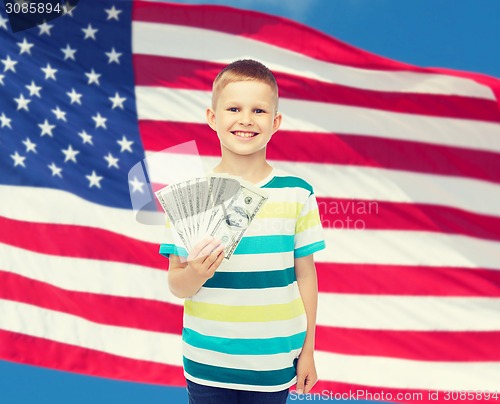 Image of smiling boy holding dollar cash money in his hand