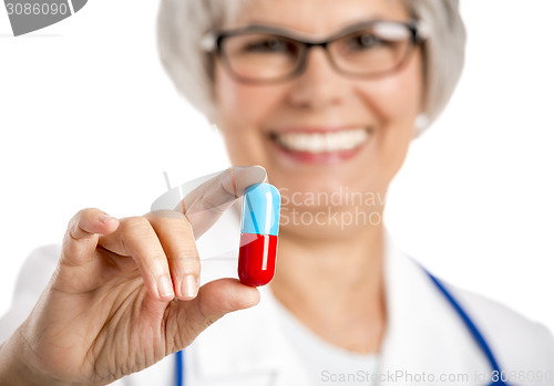 Image of Female doctor holding  a pill