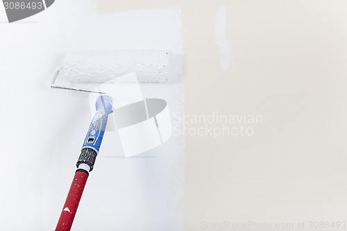 Image of Paint roller on white wall