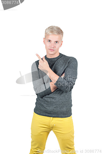 Image of Young handsome guy showing somewhere with finger