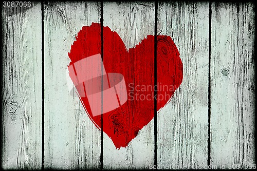 Image of Red bright abstract heart on old wooden grunge wall