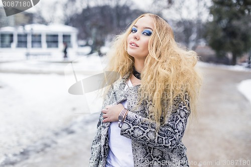 Image of Blonde lady is posing in the city park