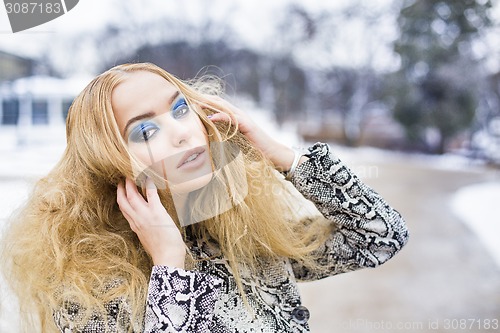 Image of Golden haired woman posing outside